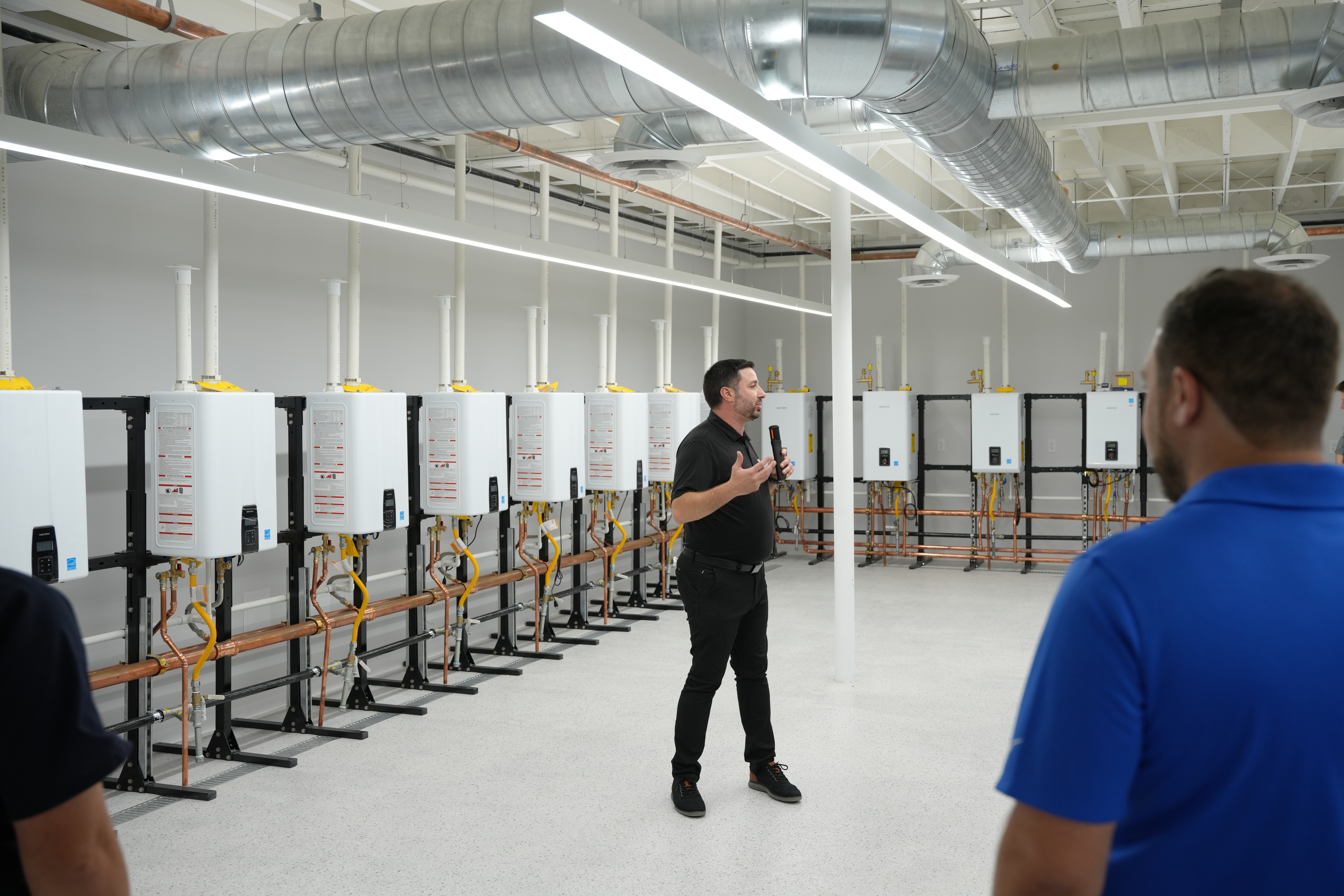 Attendees tour hands-on HVAC and water heating training installations at Navien's new Innovation Center and Training Academy in Irvine, California